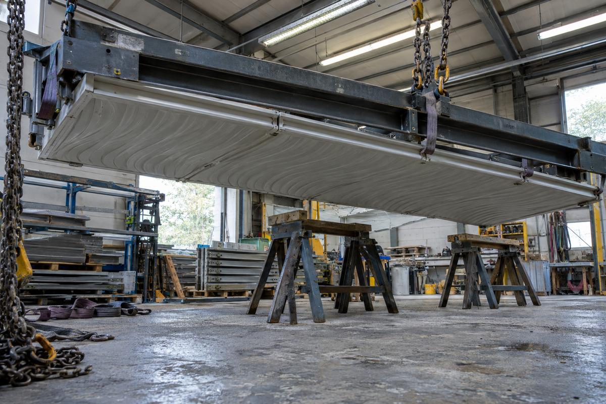 Lifting frame supporting a large multi-piece textured silicone wall-panel liner