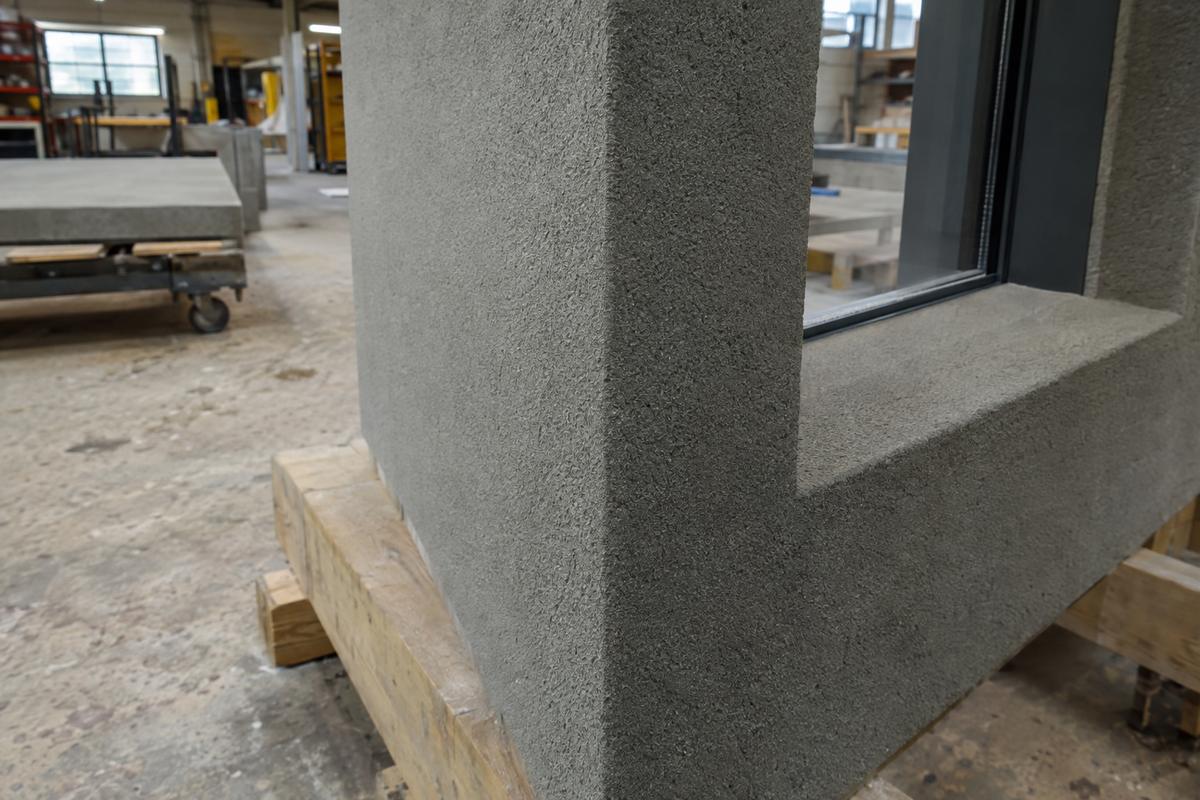 Textured cladding panel with surface wrapping cleanly into a reveal
